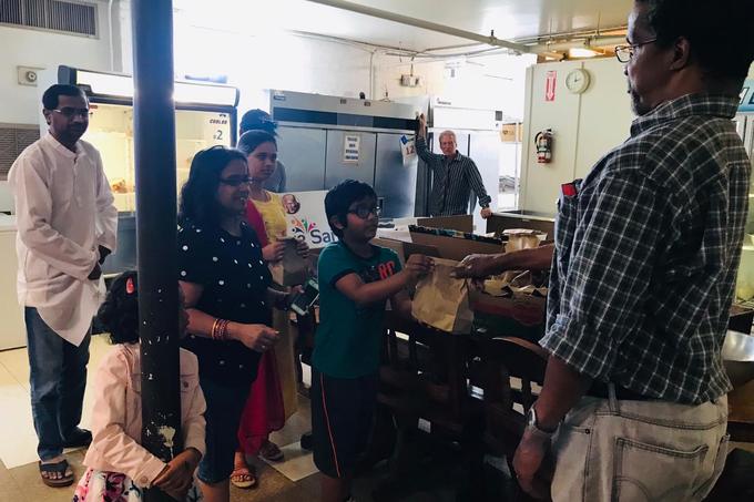 A young volunteer hands over a packed meal in Columbus, Georgia